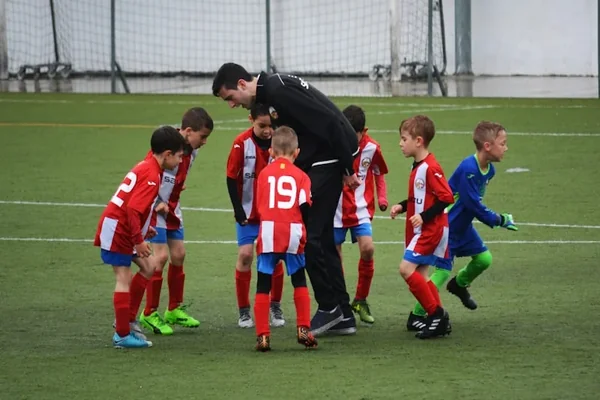 Youth soccer team huddled with their coach on the field